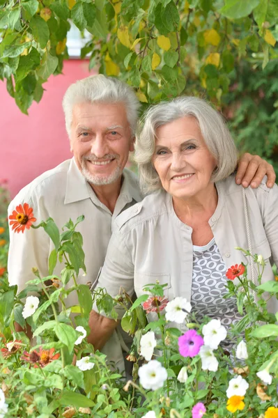 Starší pár s květinami — Stock fotografie