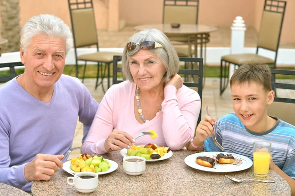 Grandparents with grandchild at breakfast — Stock Photo, Image