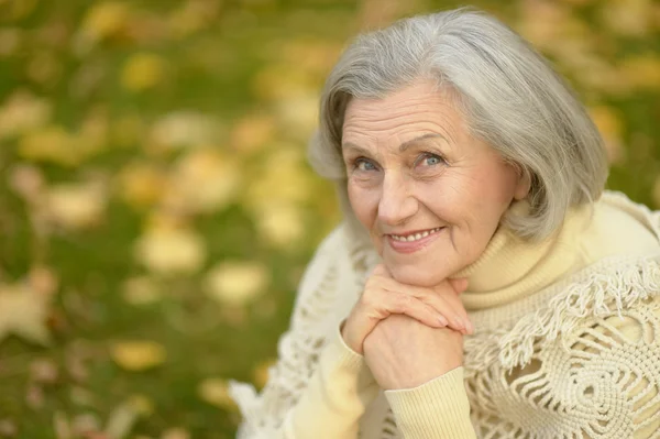 Oudere vrouw in herfstpark — Stockfoto