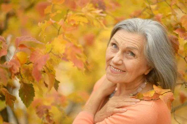 Starší žena v podzimním parku — Stock fotografie