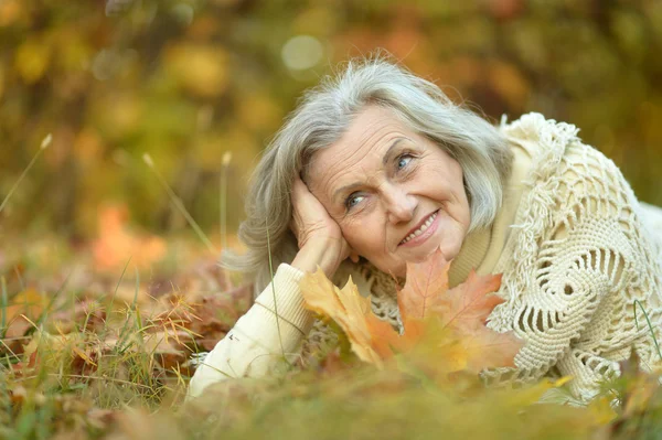 Donna anziana nel parco di autunno — Foto Stock