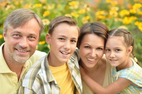 Lycklig familj på blommande fält — Stockfoto