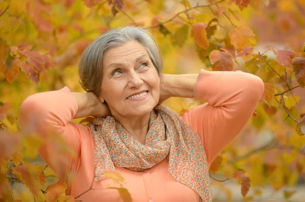 Donna anziana nel parco di autunno — Foto Stock