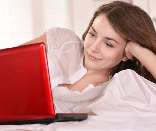 Schöne Frau im Bett mit Laptop — Stockfoto