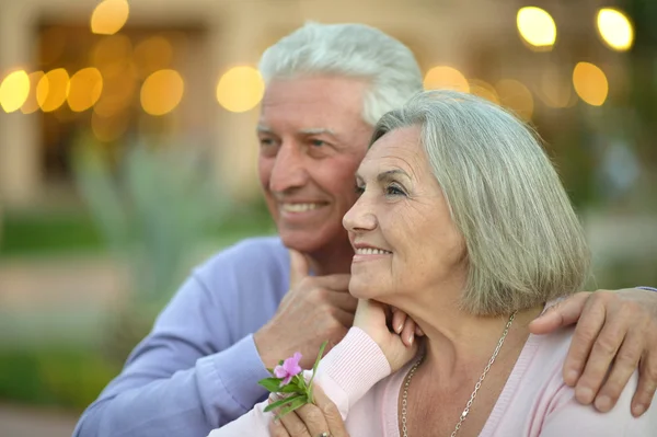 Smiling old couple with flower — Stock Photo, Image