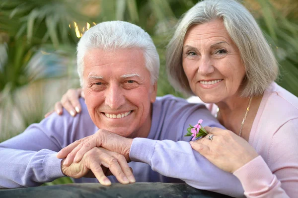 Sorrindo casal velho com flor — Fotografia de Stock