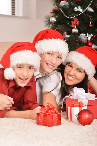 Mutter und Kinder in Weihnachtsmützen — Stockfoto