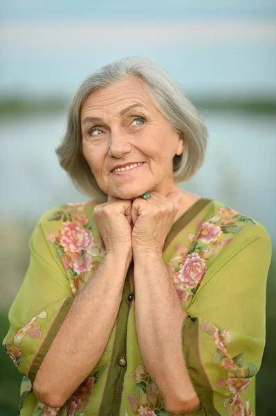 Oudere vrouw in de buurt van lake — Stockfoto