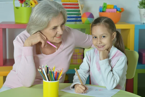 Grandmother with granddaughter drawing together — Stock Photo, Image