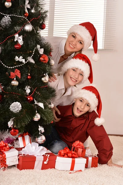 Mutter und Kinder in Weihnachtsmützen — Stockfoto