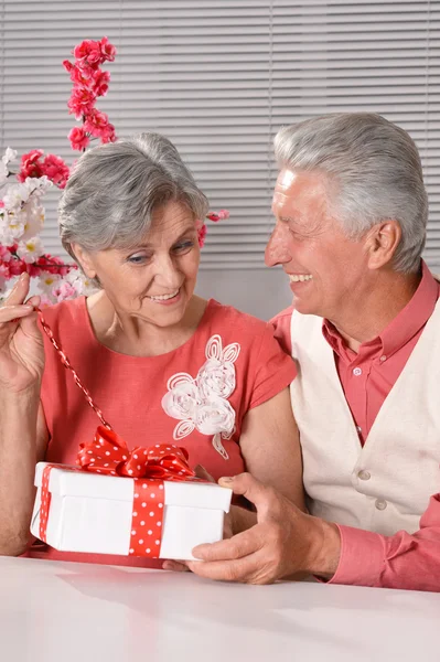 Lyckliga äldre par med gåva — Stockfoto