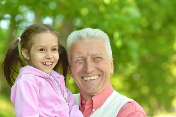 Man met kleindochter in voorjaar park — Stockfoto