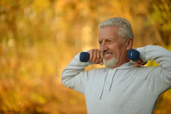 Anciano haciendo ejercicio con pesas —  Fotos de Stock