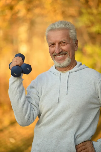 Oudere man uitoefenen met halters — Stockfoto