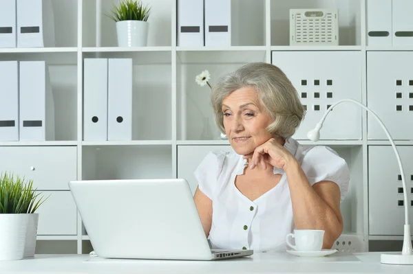 Пожилая женщина работает на ноутбуке — стоковое фото