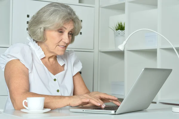 Oudere vrouw die op laptop werkt — Stockfoto