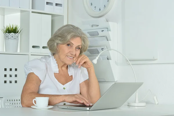 Elderly woman working on laptop — Stock Photo, Image