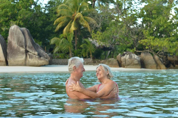 Bejaarde echtpaar rusten op tropisch strand — Stockfoto