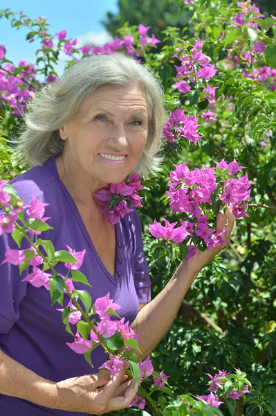 Older woman with flowers — Stock Photo, Image