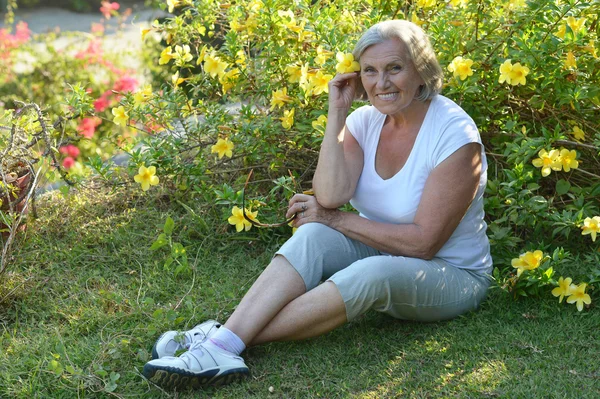 Starsza kobieta w tropikalnym ogrodzie — Zdjęcie stockowe