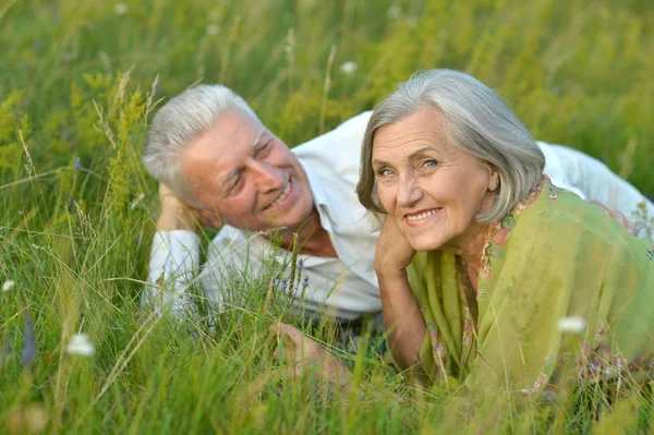 Äldre par liggande på gräs — Stockfoto