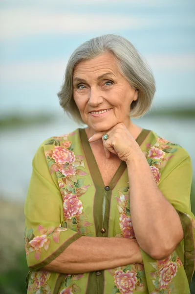 Oudere vrouw in de buurt van lake — Stockfoto