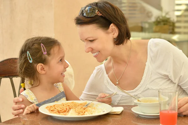 Chica con madre comiendo en la mesa —  Fotos de Stock