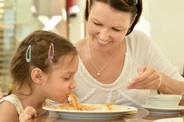 Chica con madre comiendo en la mesa — Foto de Stock