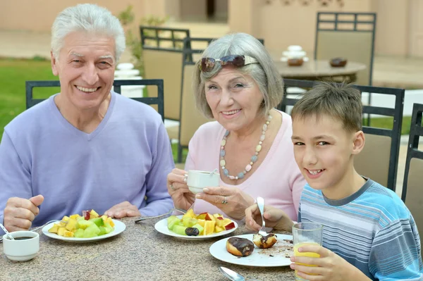 Grandparents with grandchild at breakfast — Stock Photo, Image