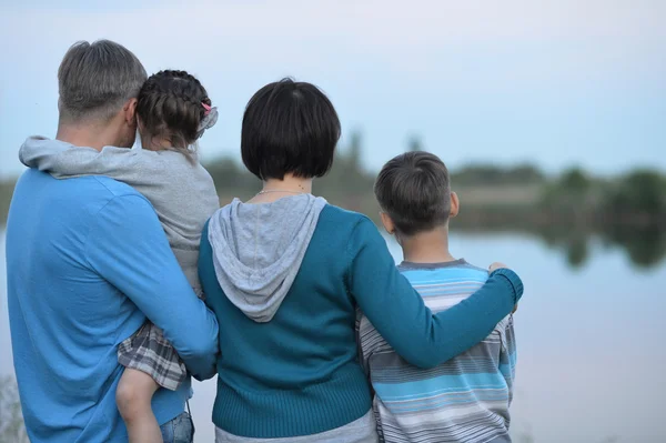 Familia feliz cerca del lago — Foto de Stock