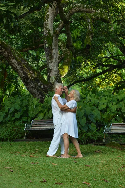 Bejaarde echtpaar in tropische tuin — Stockfoto