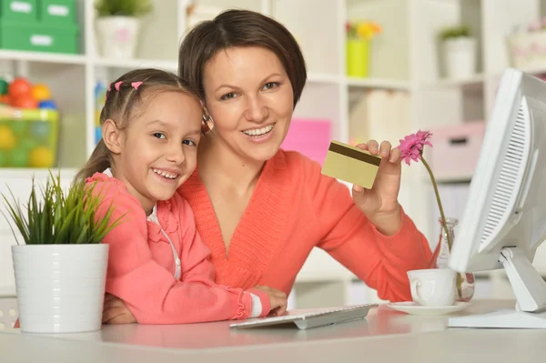 Meisje met moeder doen online winkelen — Stockfoto