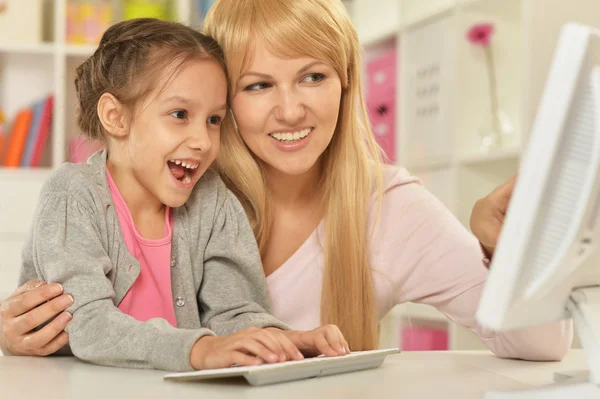 Flicka som leker med mamma på dator — Stockfoto