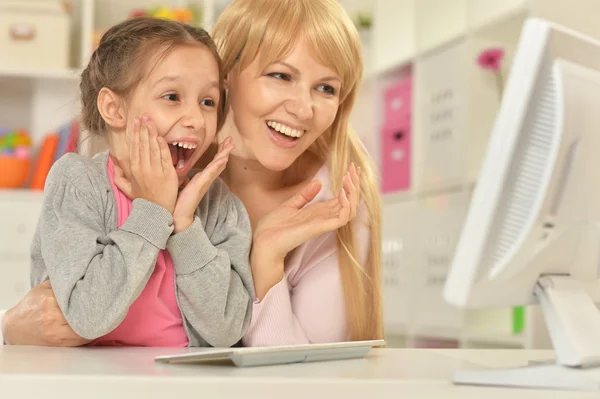 Flicka som leker med mamma på dator — Stockfoto