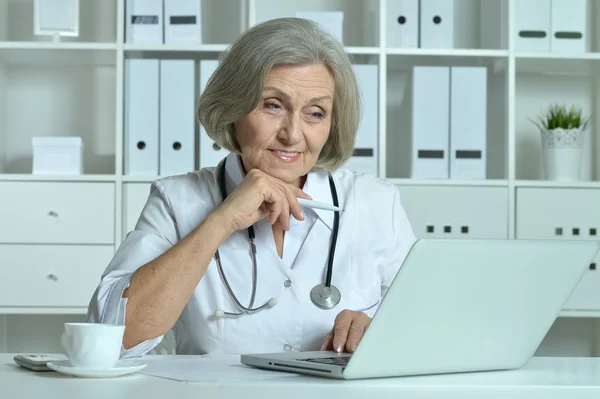 Happy senior doctor with laptop — Stock Photo, Image