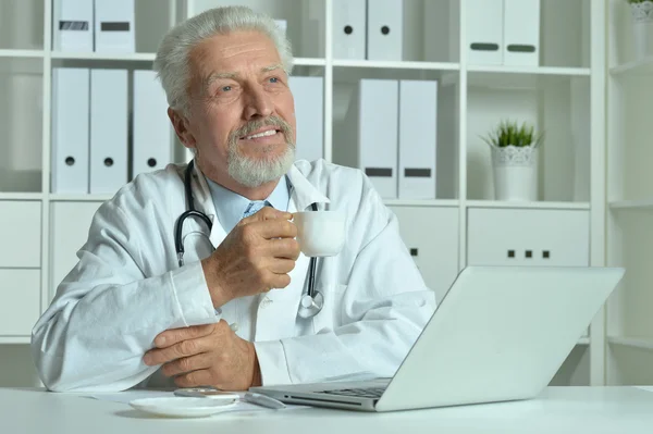 Medico anziano con laptop — Foto Stock