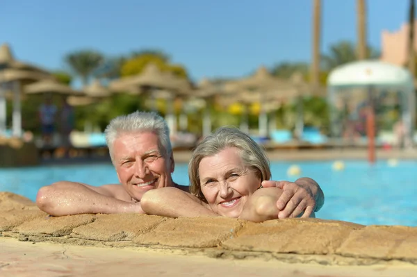 Старшая пара отдыхает в бассейне — стоковое фото