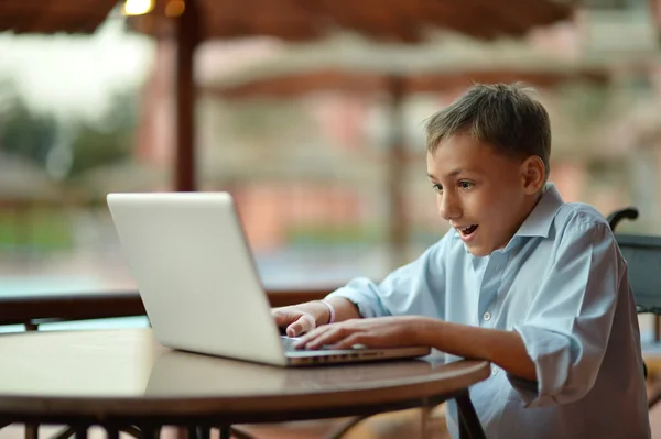 Menino com laptop na mesa — Fotografia de Stock