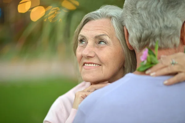 Lachende oude paar met bloem — Stockfoto