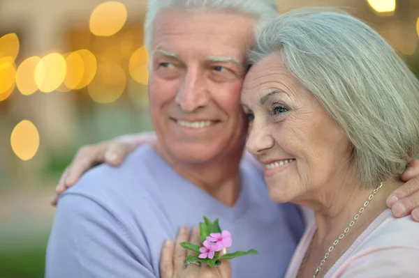 Улыбающаяся пожилая пара с цветами — стоковое фото