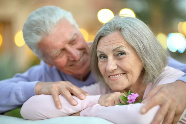 Sorrindo casal velho com flor — Fotografia de Stock