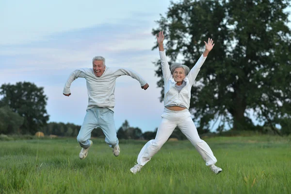 Senior paar uitoefenen in zomer veld — Stockfoto