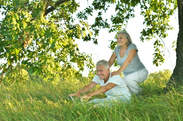 Старшая пара, занимающаяся спортом в летнем поле — стоковое фото