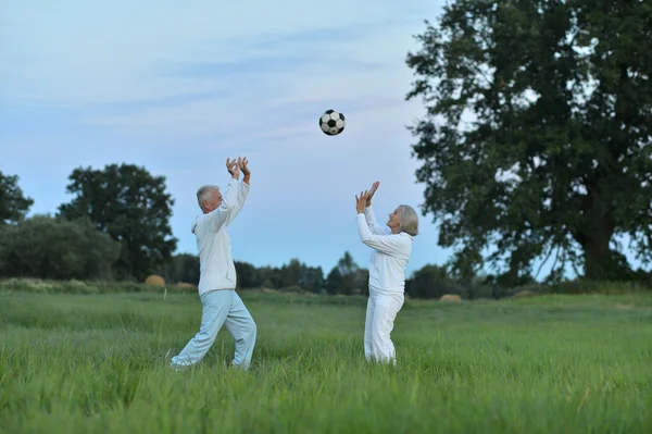 Starší pár s míčem — Stock fotografie