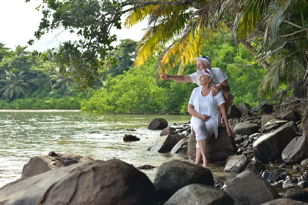 Äldre par resten på tropical beach — Stockfoto