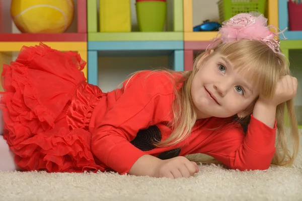 Kleines Mädchen im roten Kleid zu Hause — Stockfoto