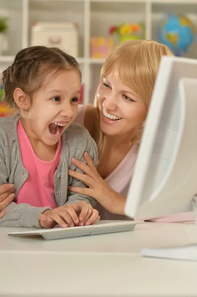 Menina brincando com a mãe no computador — Fotografia de Stock