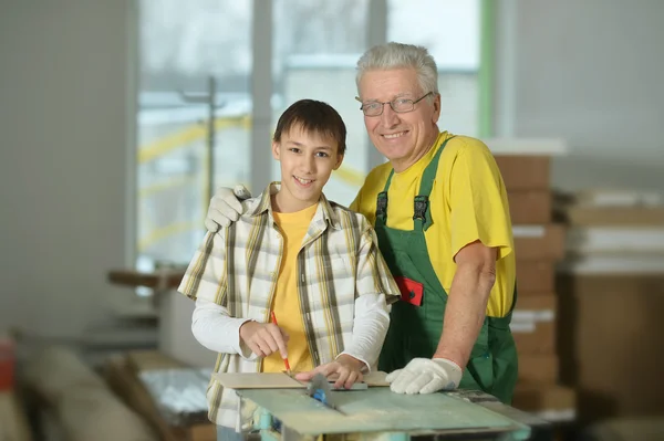 Man och barnbarn reparera i rummet — Stockfoto