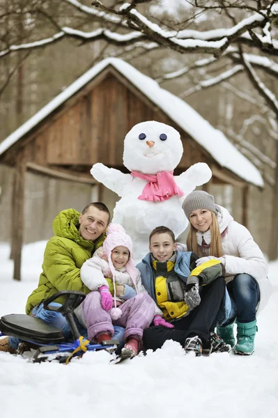 Familj spelar i nysnö — Stockfoto