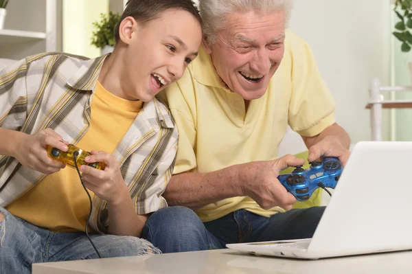 Jongen en grootvader spelen van computerspel — Stockfoto